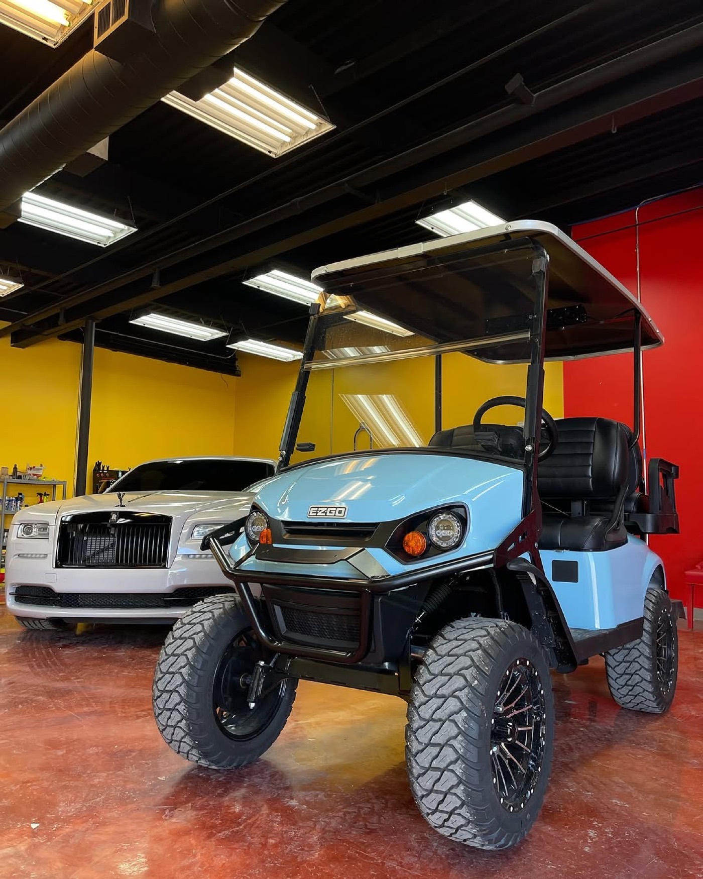 Inside the shop, wrapped golf cart and Rolls-Royce